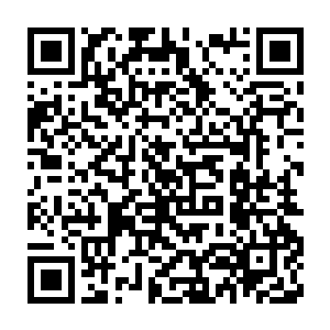 几个戴着安全帽的长风商团的施工人员一边用几根钢绳拴在吊版上二维码生成