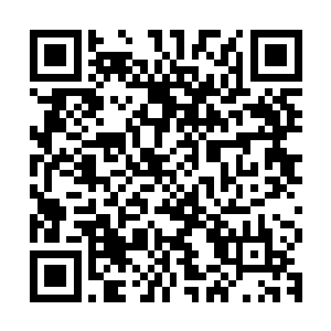 爬上云台的焊工手脚麻利的在测算好位置焊上下面的三脚支撑架二维码生成